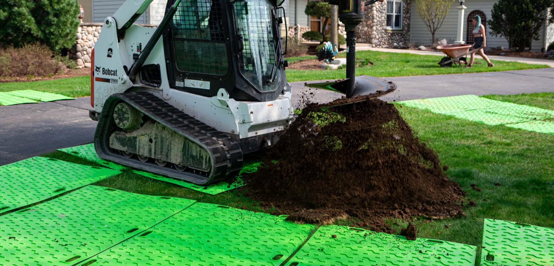 a bobcat auger parked on bam bad ass mats