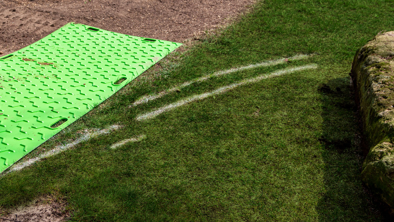 Protected grass that a forklift with treads and a BAM Bad Ass Mats ground protection sat moments before